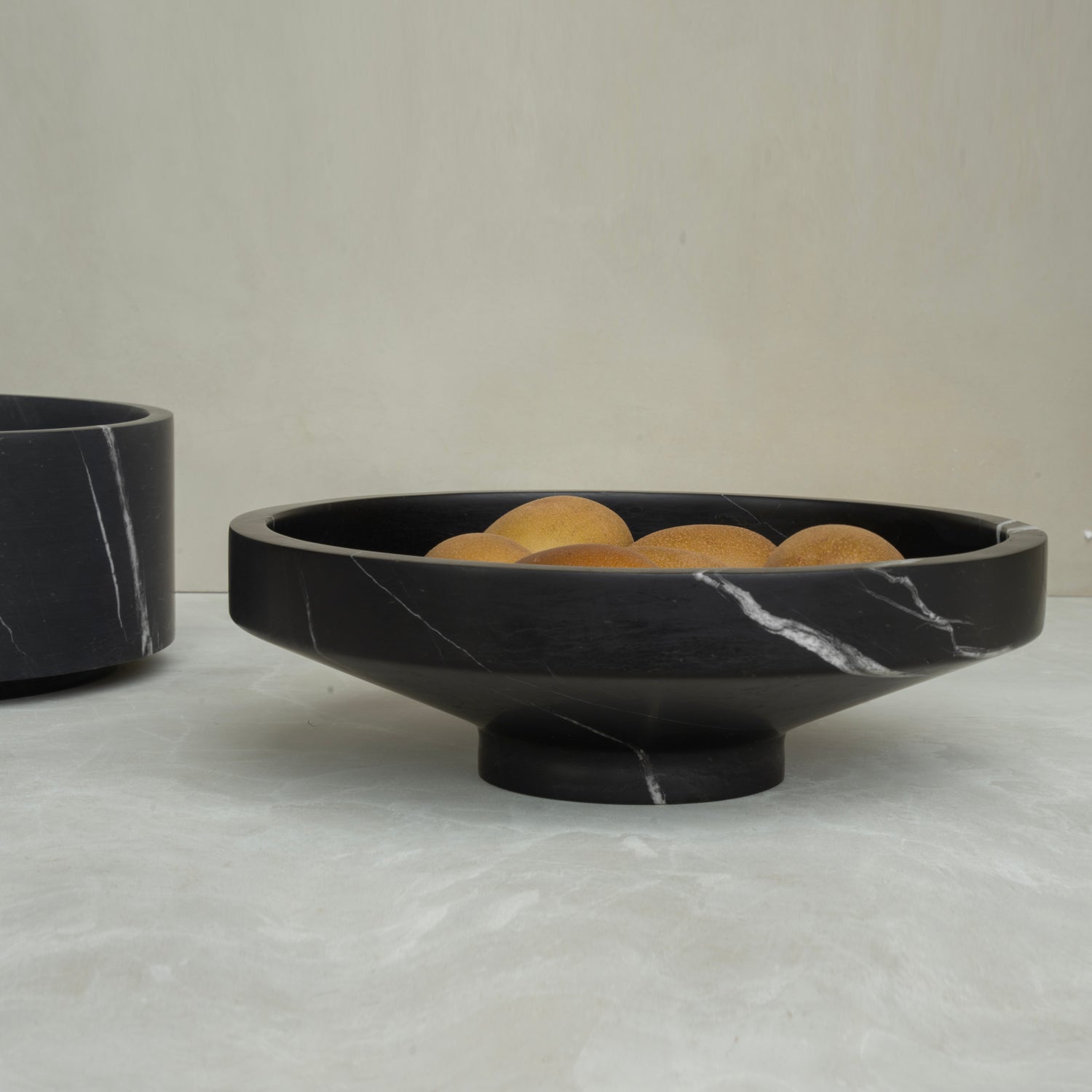 Black marble bowl with sculptural round shape and veined surface