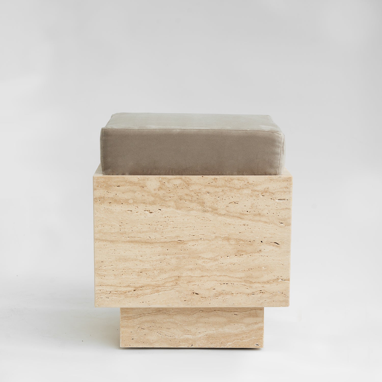 Travertine cube stool with velvet cushion in modern setting