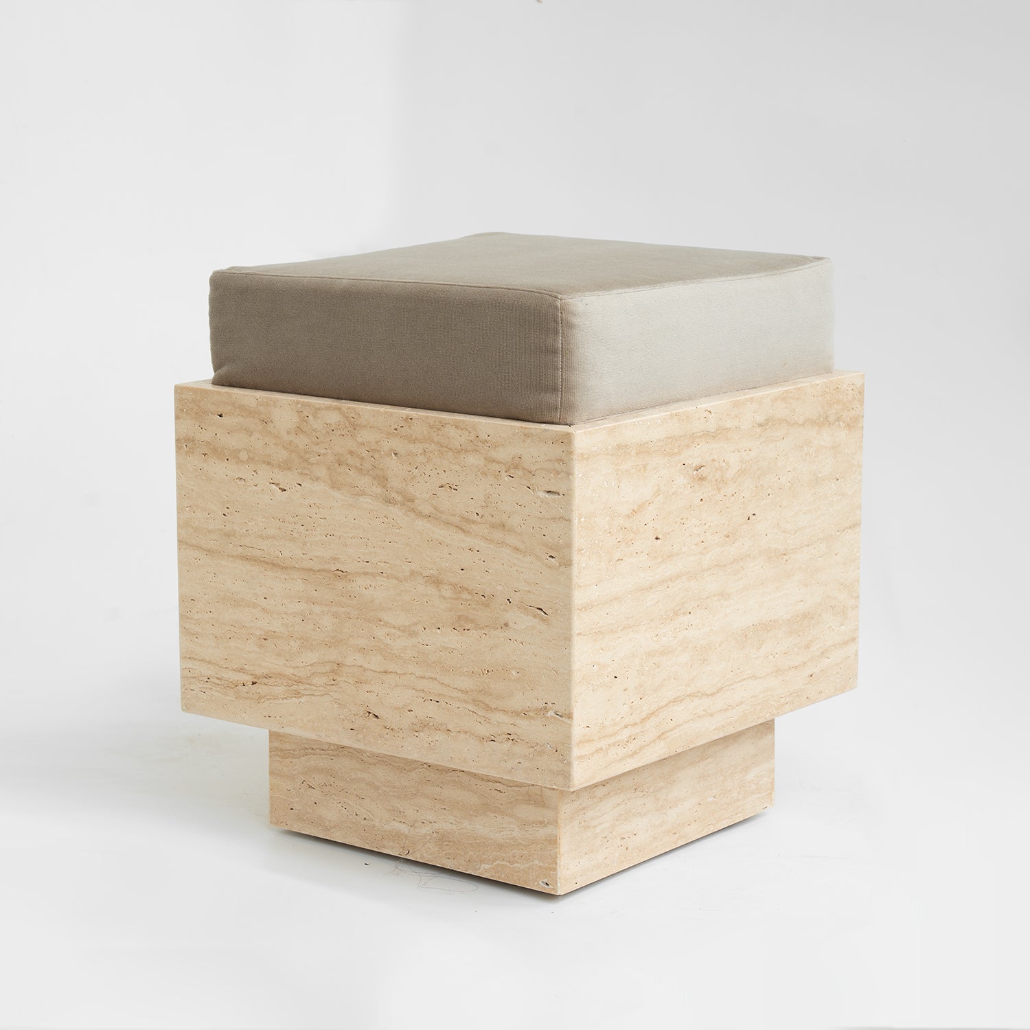 Travertine cube stool with velvet cushion in modern setting