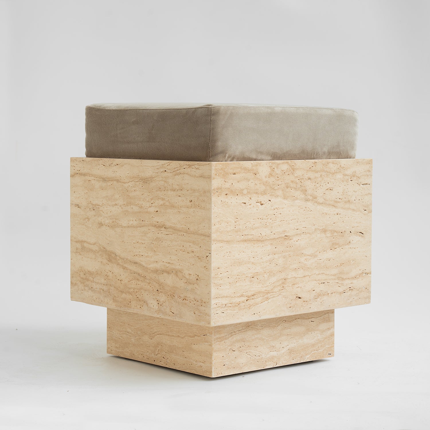 Travertine cube stool with velvet cushion in modern setting