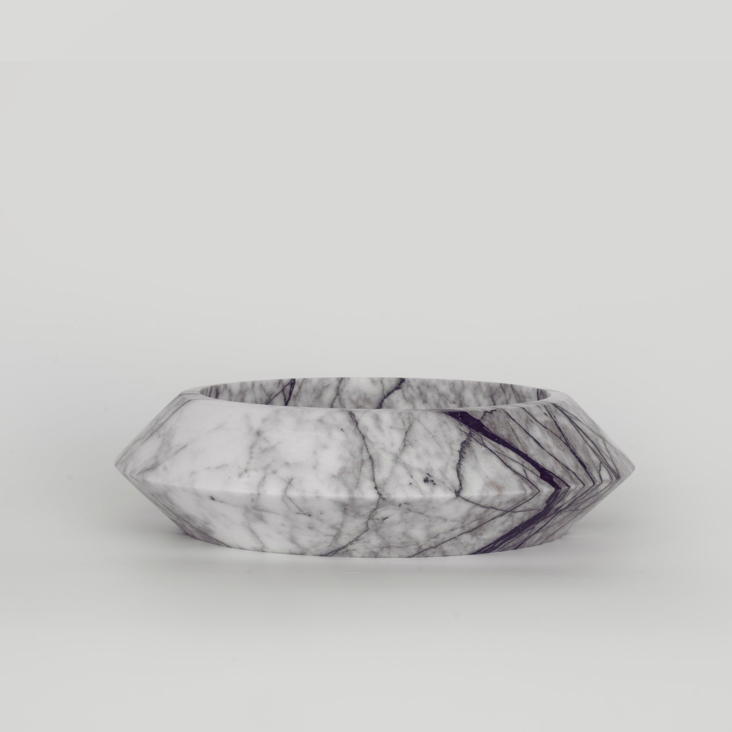White marble bowl with lilac veining on flat surface