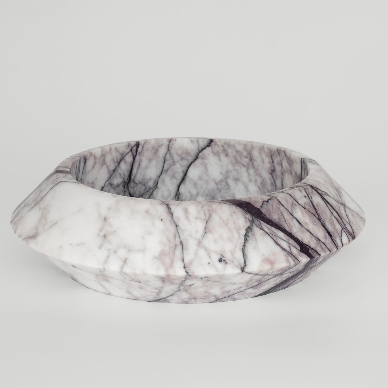 White marble bowl with lilac veining on flat surface