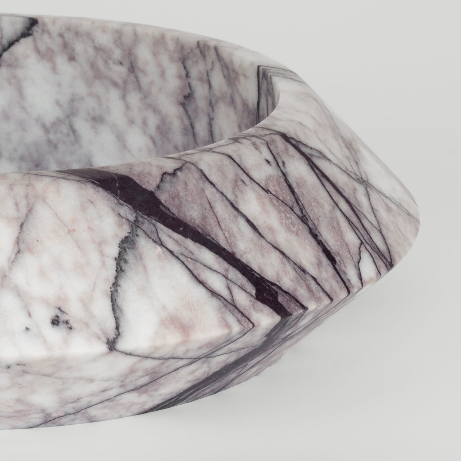 White marble bowl with lilac veining on flat surface