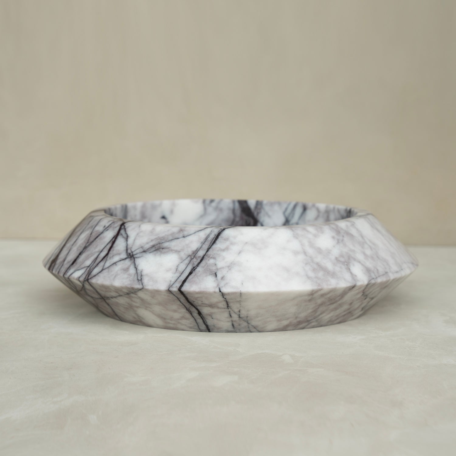 White marble bowl with lilac veining on flat surface