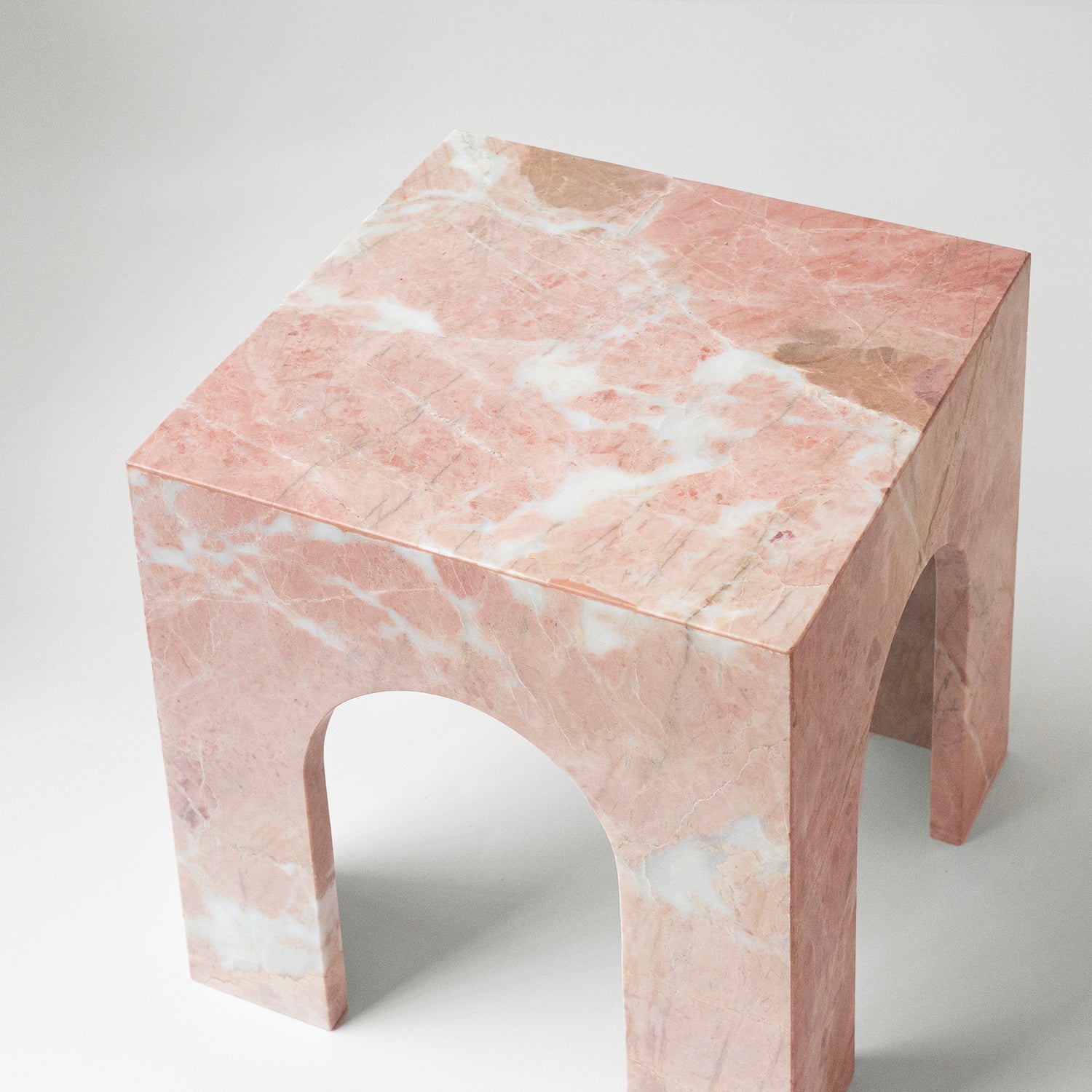 Pink marble side table with arched base and square top