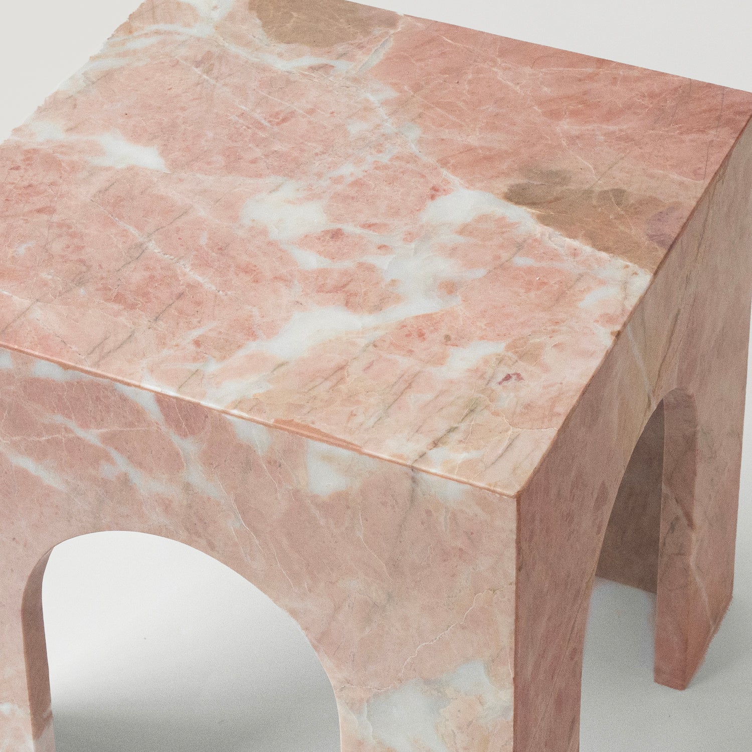 Pink marble side table with arched base and square top