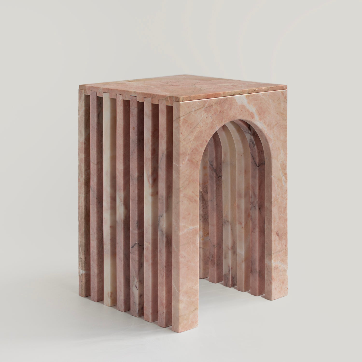 Pink marble side table with curved arched marble base