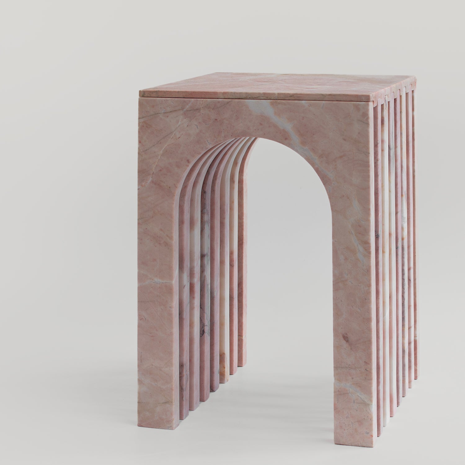 Pink marble side table with curved arched marble base