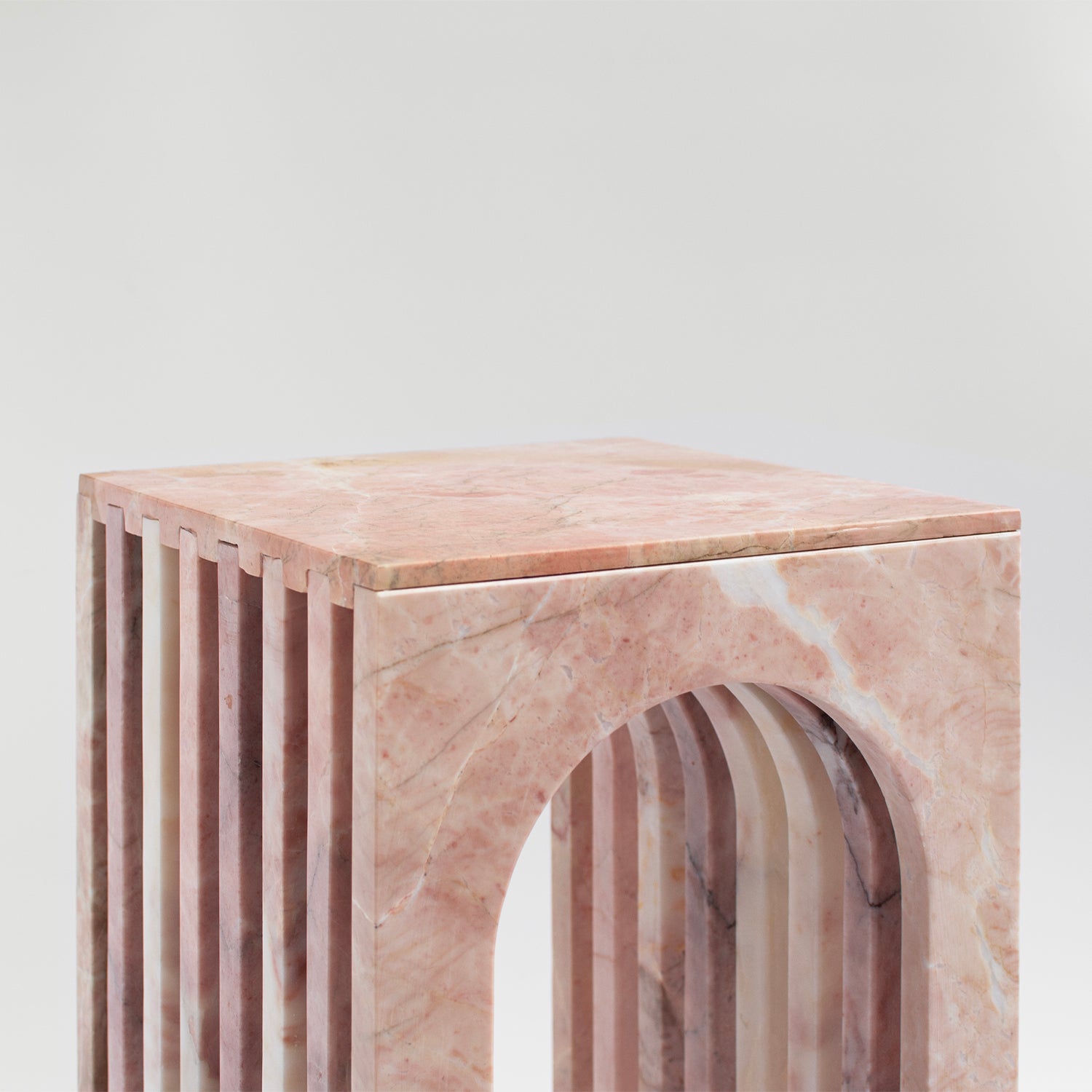 Pink marble side table with curved arched marble base