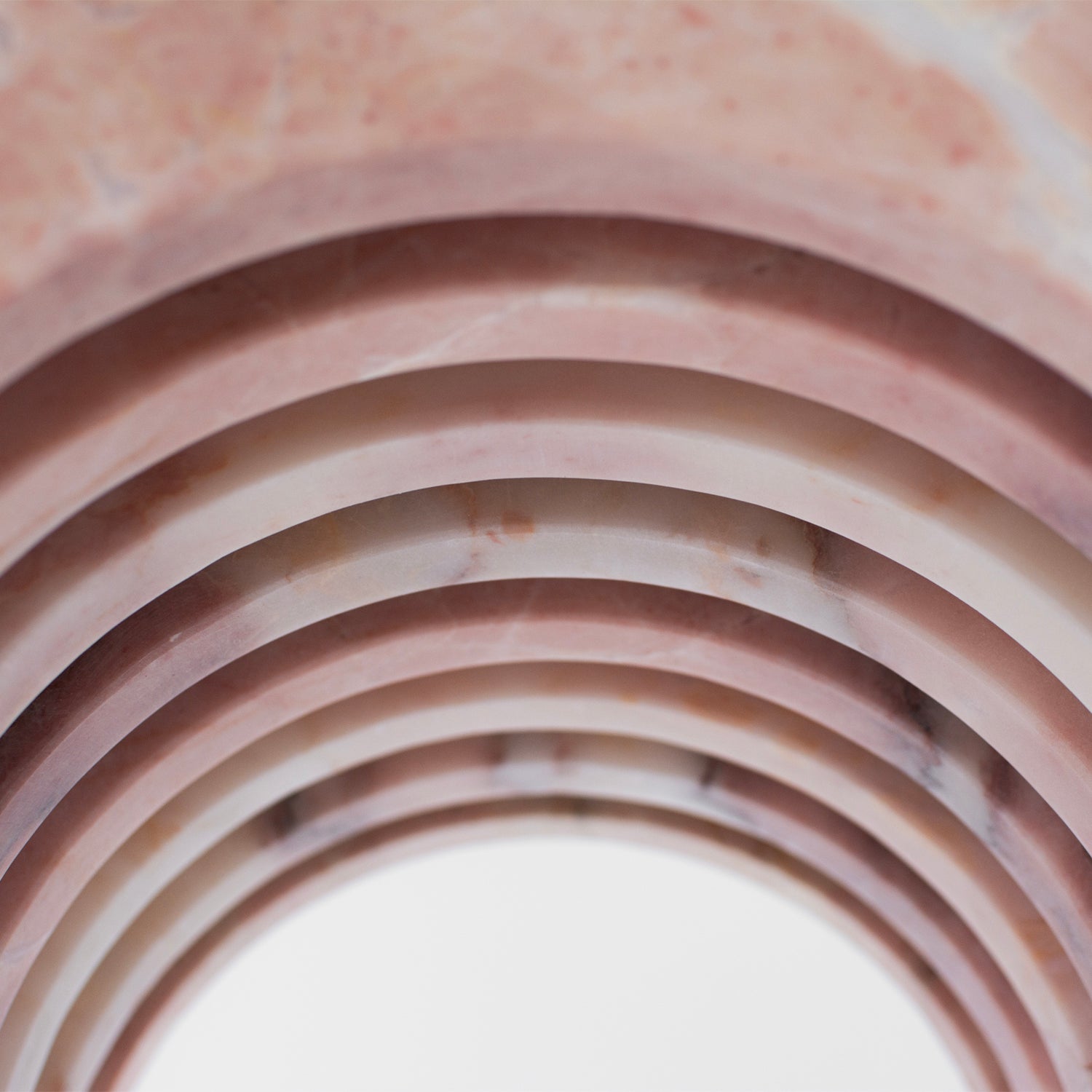 Pink marble side table with curved arched marble base