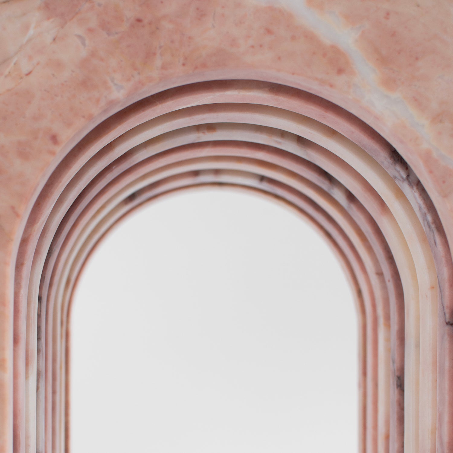 Pink marble side table with curved arched marble base