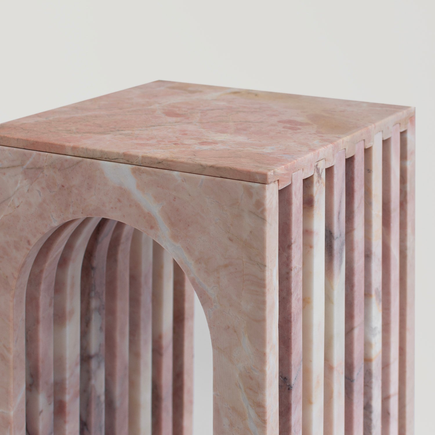 Pink marble side table with curved arched marble base