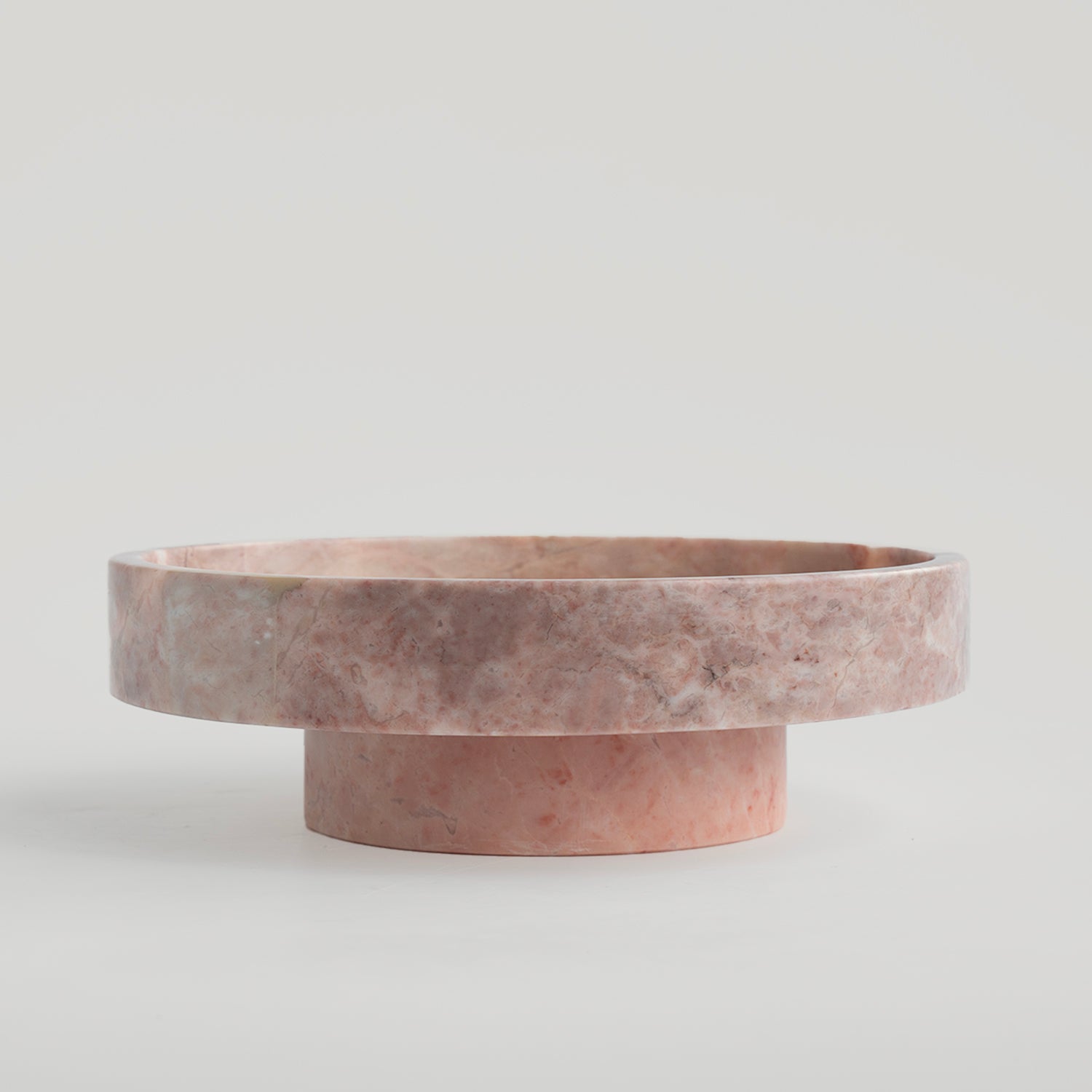 Pink marble bowl with rounded shape on neutral surface