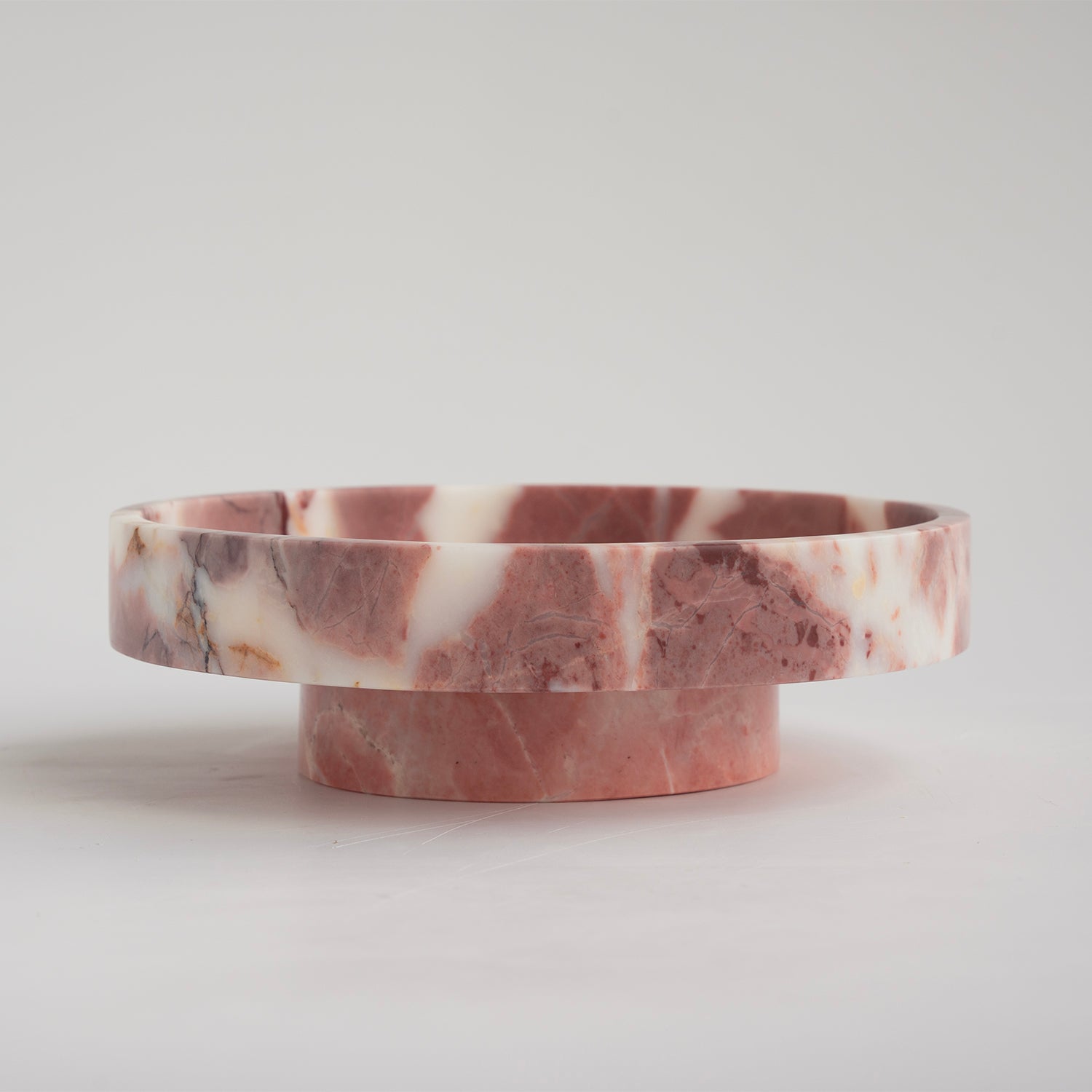 Pink marble bowl with rounded shape on neutral surface