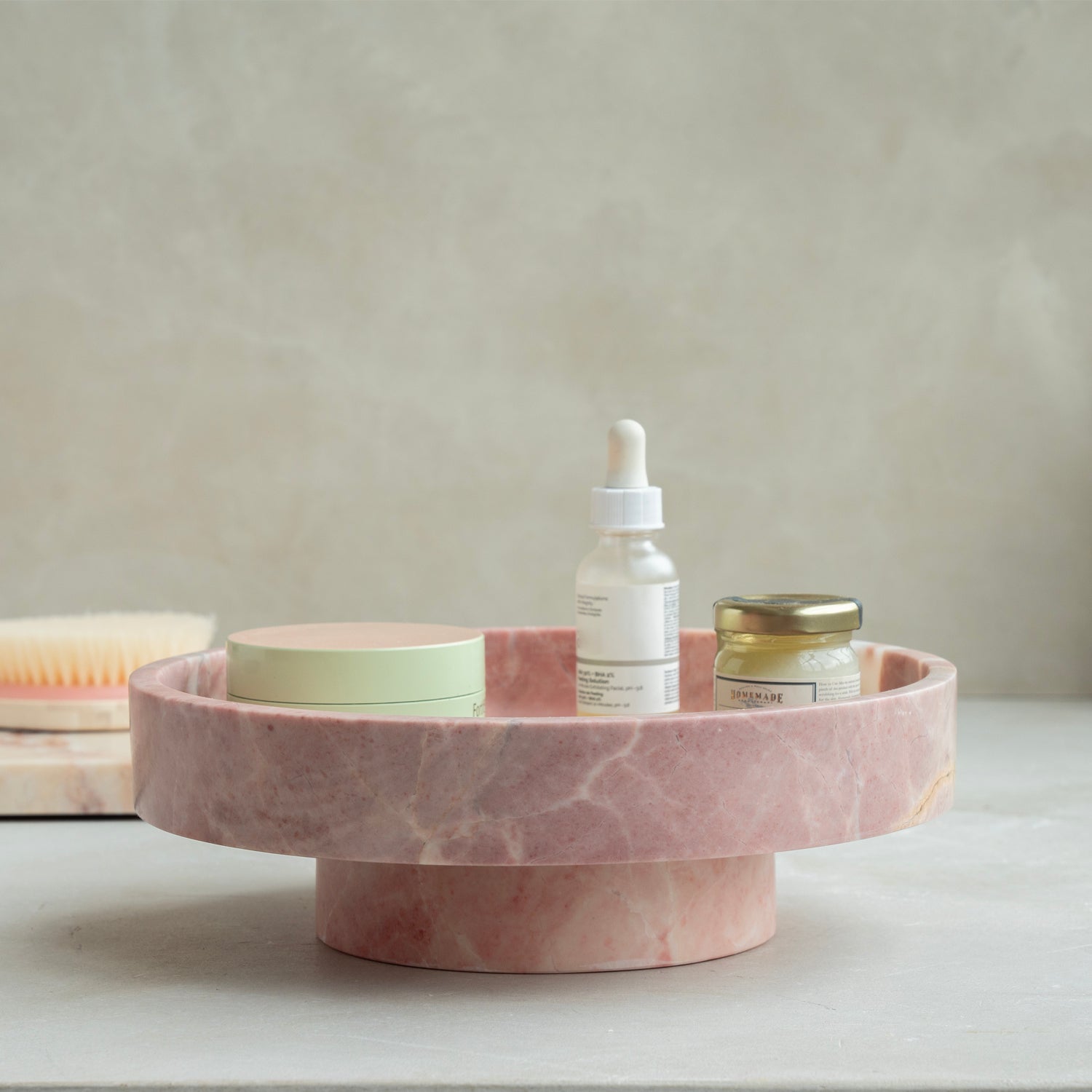 Pink marble bowl with rounded shape on neutral surface