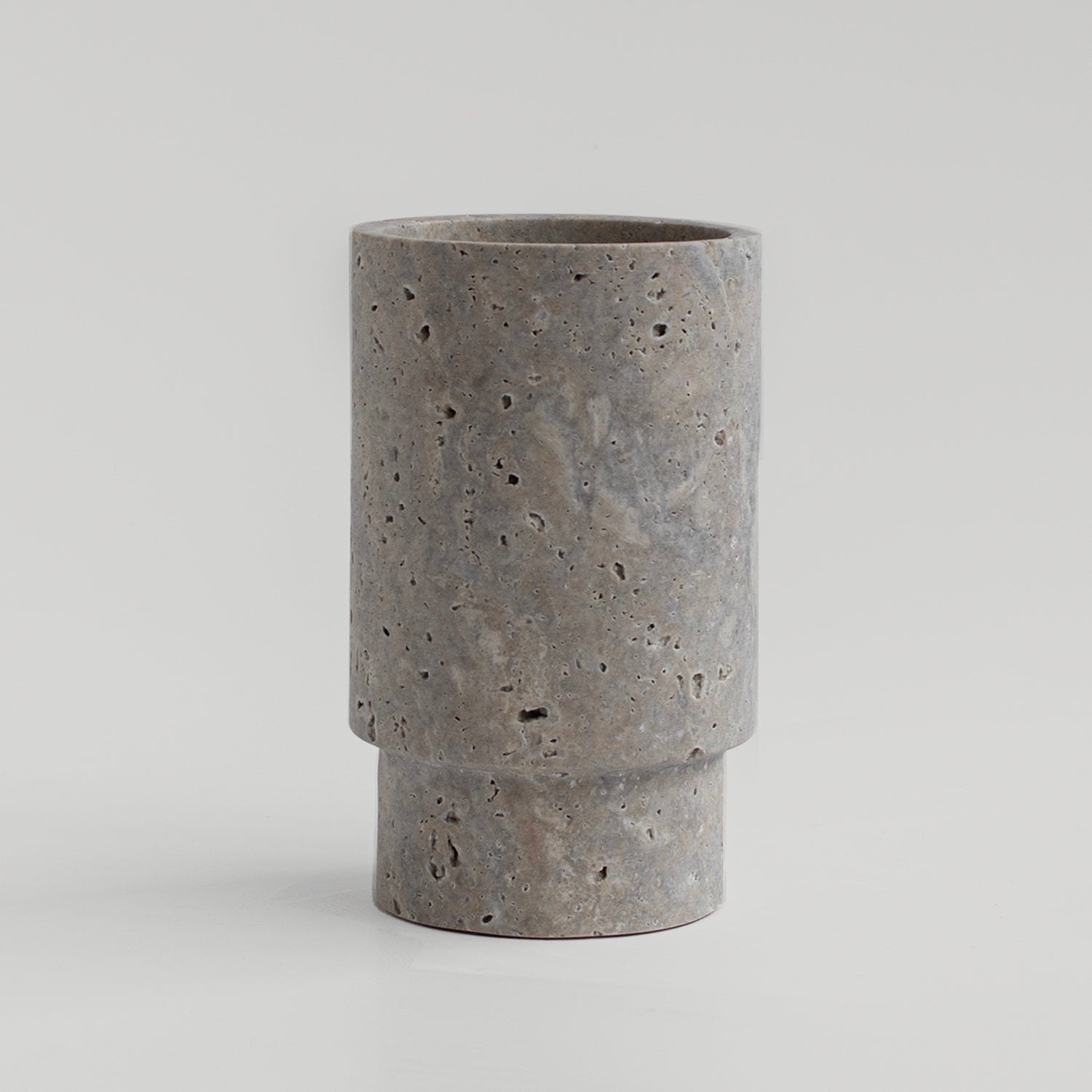 Silver travertine vase and wine bottle holder on table