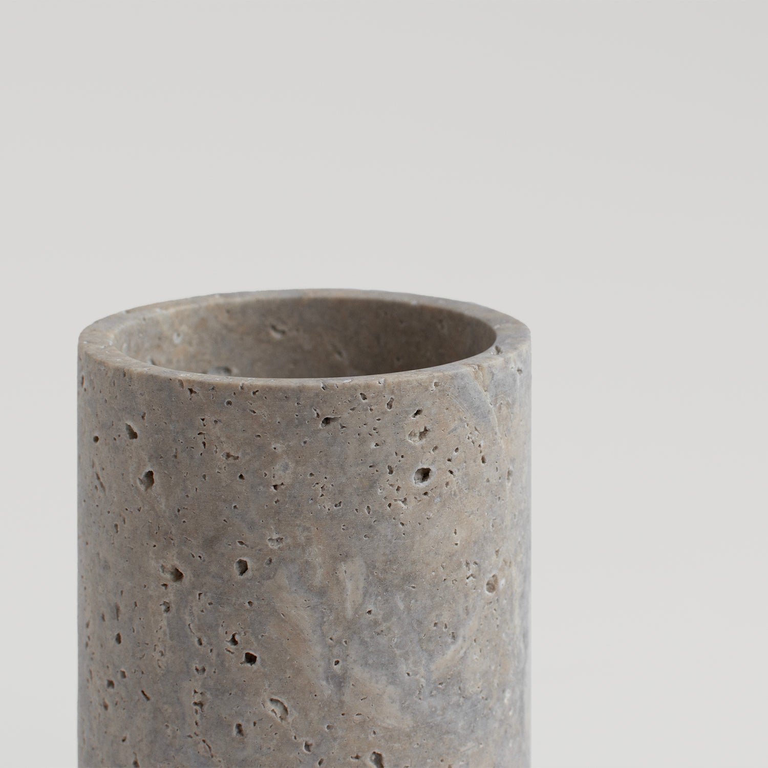 Silver travertine vase and wine bottle holder on table