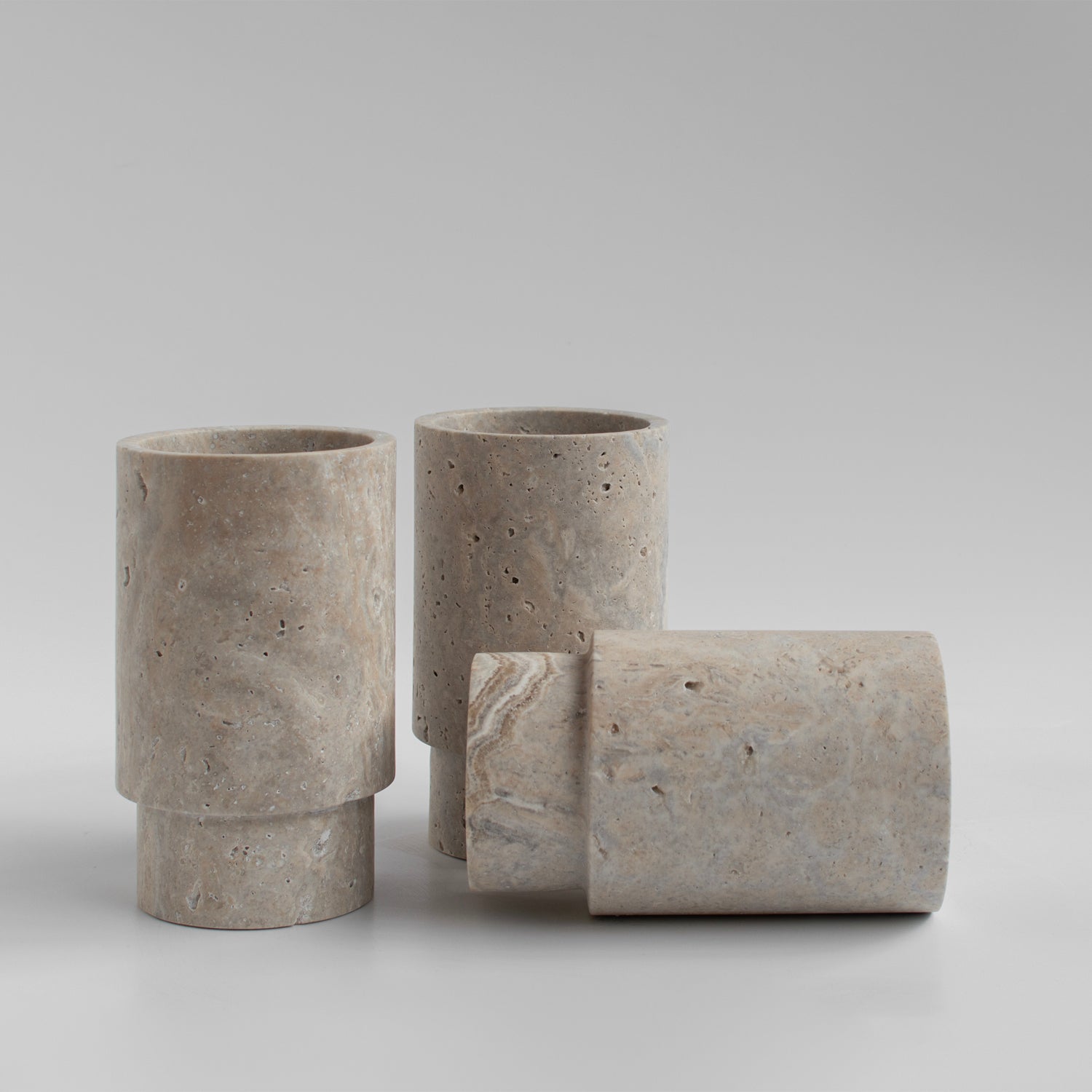 Silver travertine vase and wine bottle holder on table