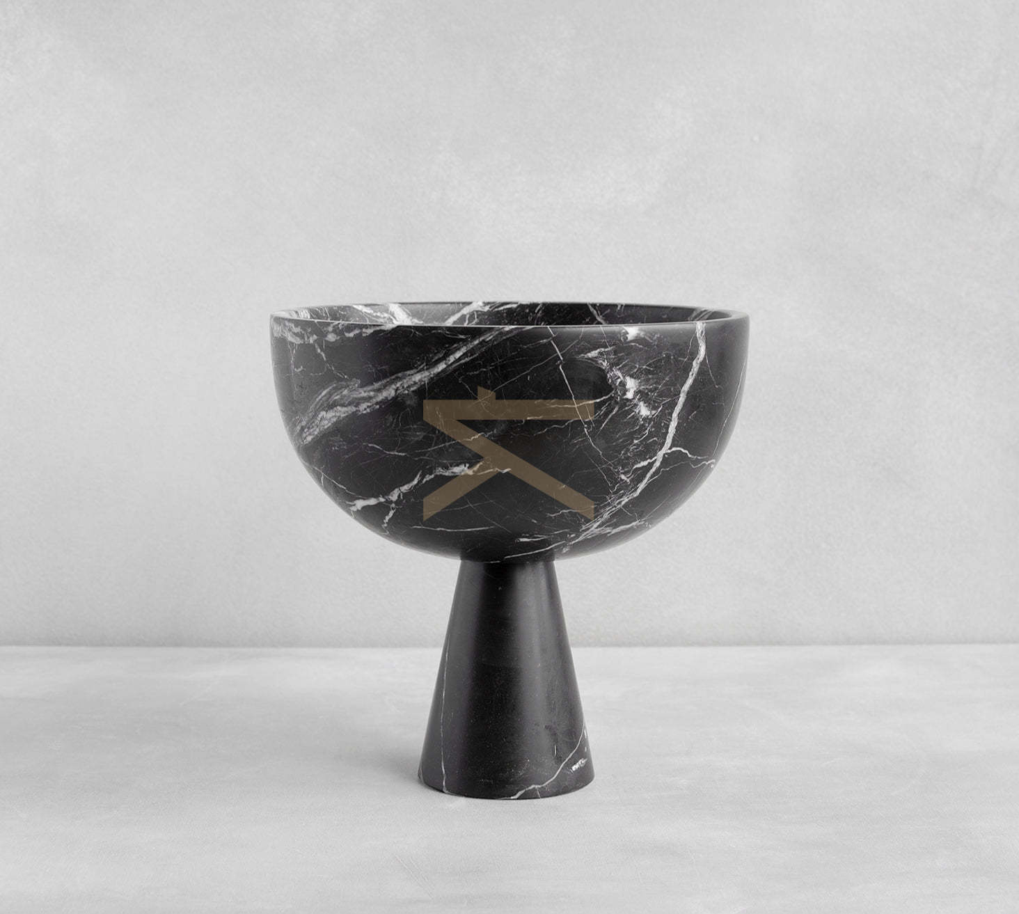 Black marble pedestal bowl with white veining on table