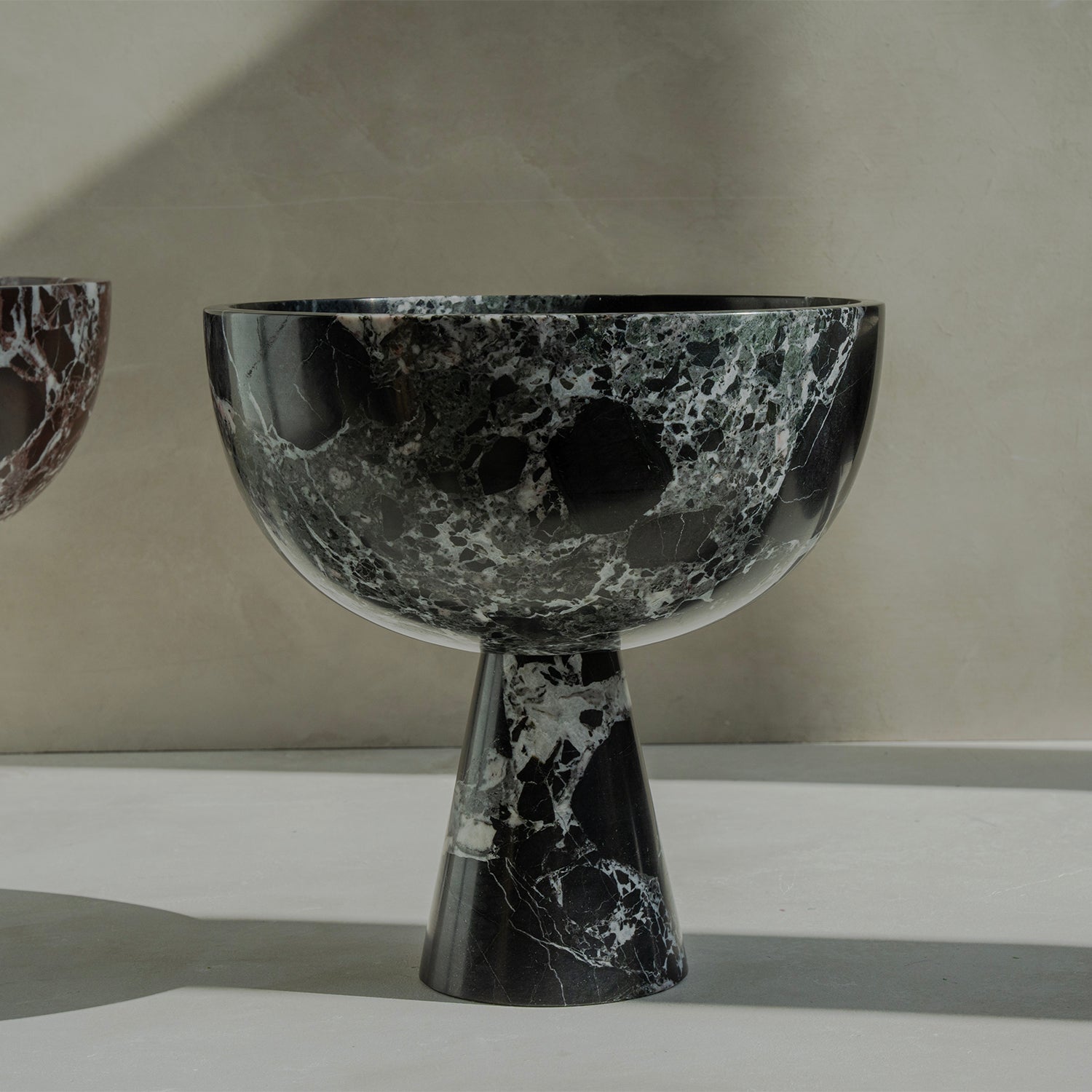 Black marble pedestal bowl with green marble veins