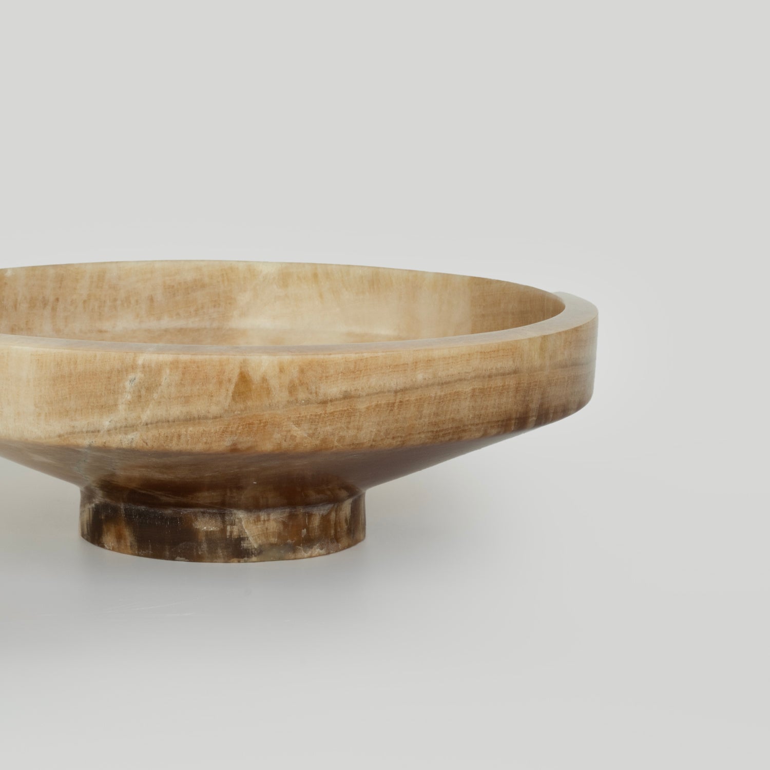 Onyx bowl with natural veining on white stone surface