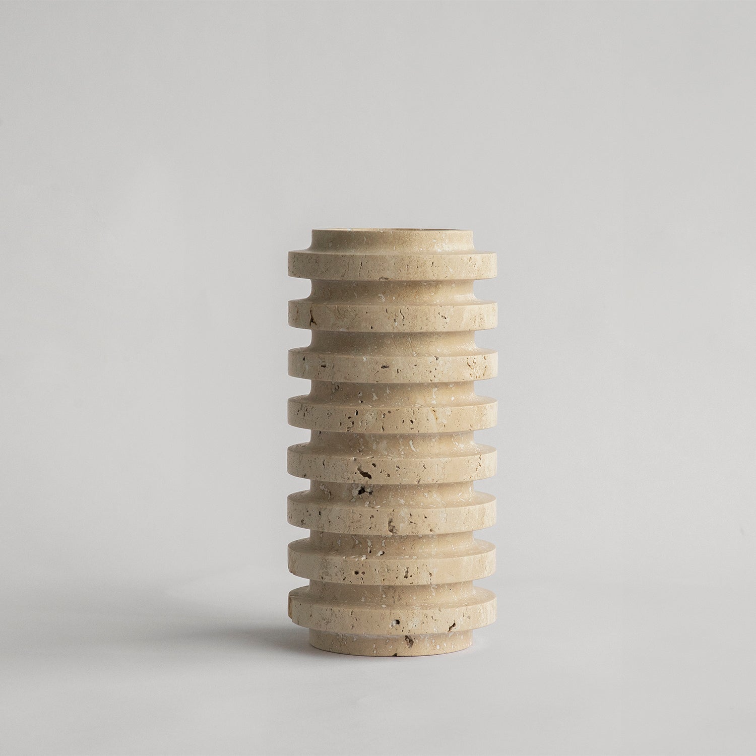 Travertine vase with natural stone layers on table