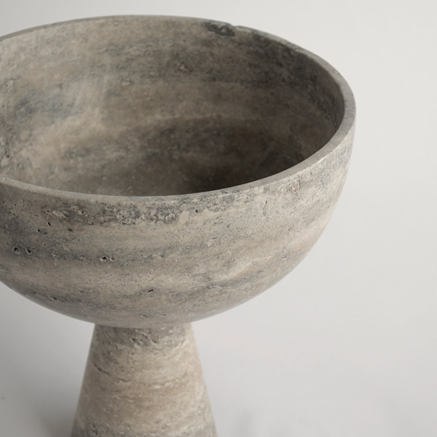 Silver travertine pedestal bowl with matte marble surface