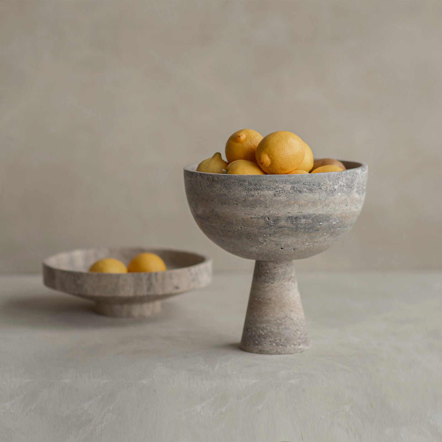 Silver travertine pedestal bowl with matte marble surface