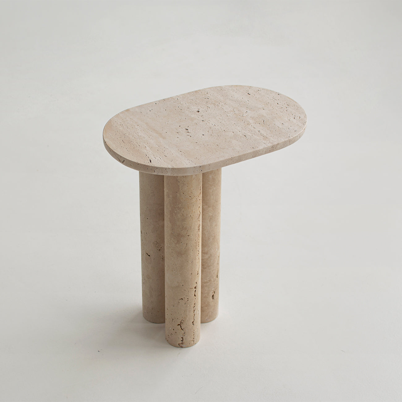 Travertine side table with three stone cylinder legs
