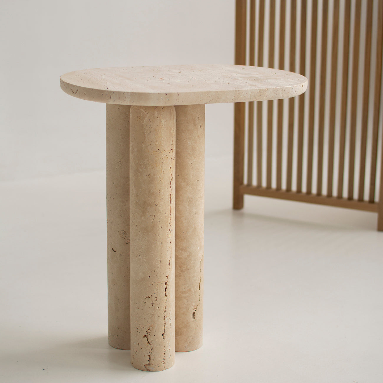 Travertine side table with three stone cylinder legs