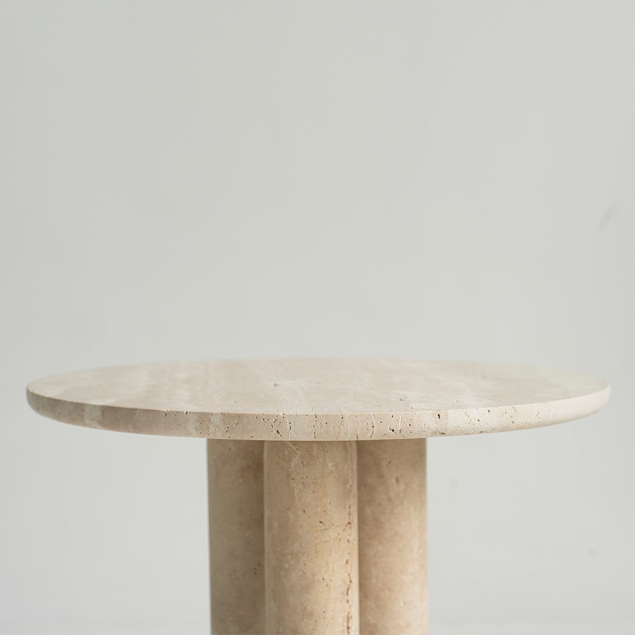 Travertine side table with round top and three stone legs