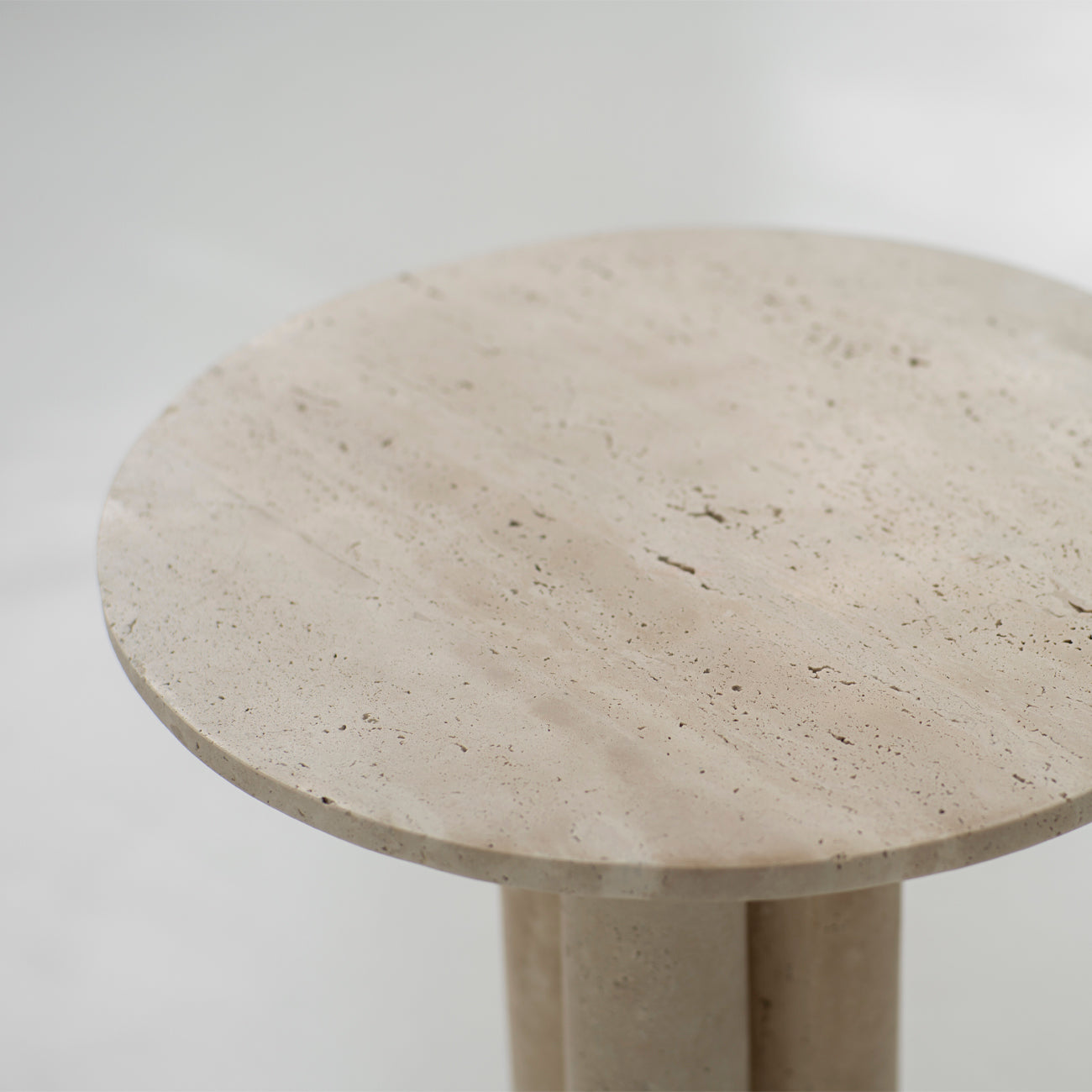 Travertine side table with round top and three stone legs