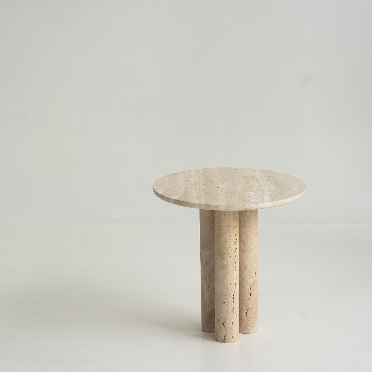 Travertine side table with round top and three stone legs
