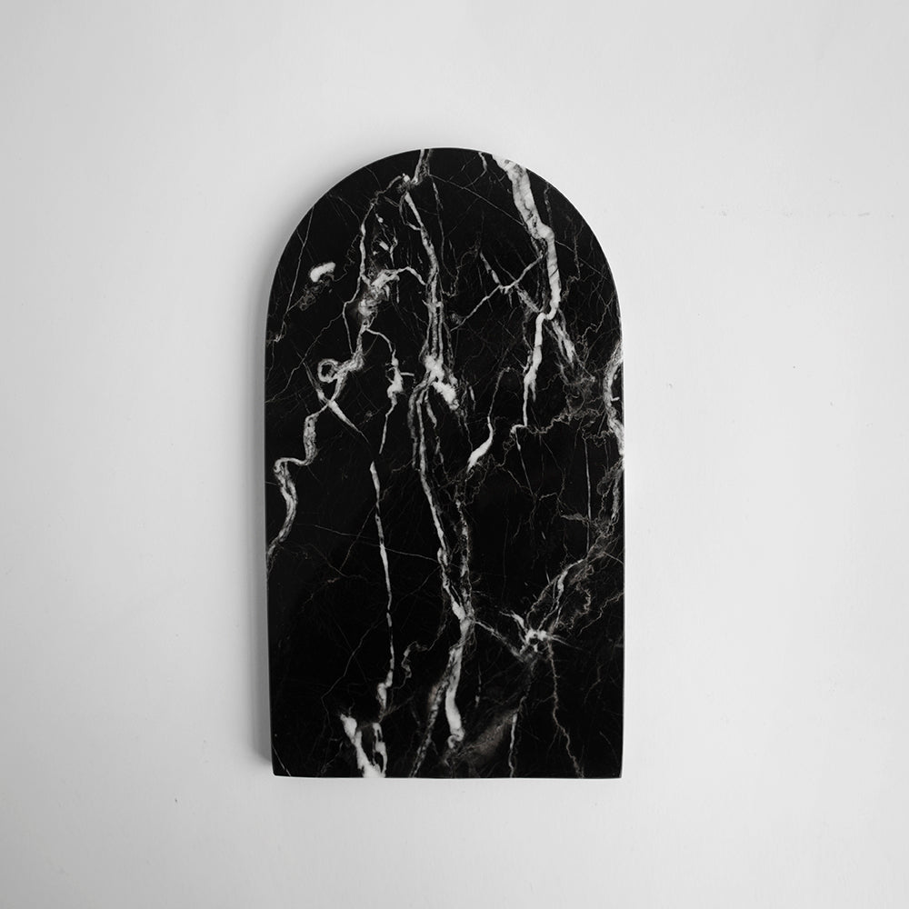 Black marble serving tray with arched shape and white veining