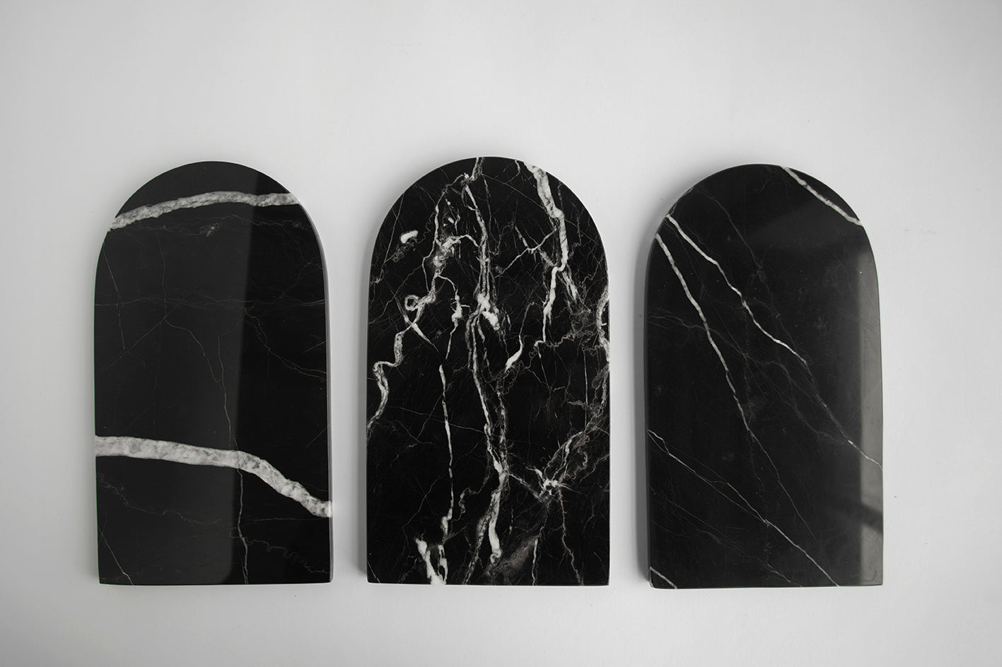 Black marble serving tray with arched shape and white veining