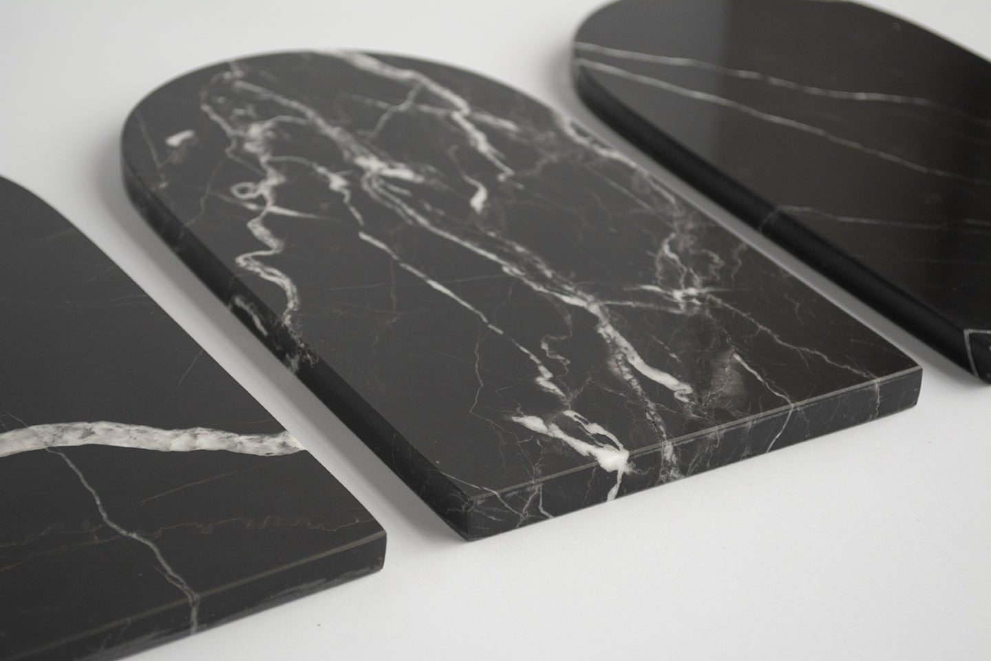 Black marble serving tray with arched shape and white veining