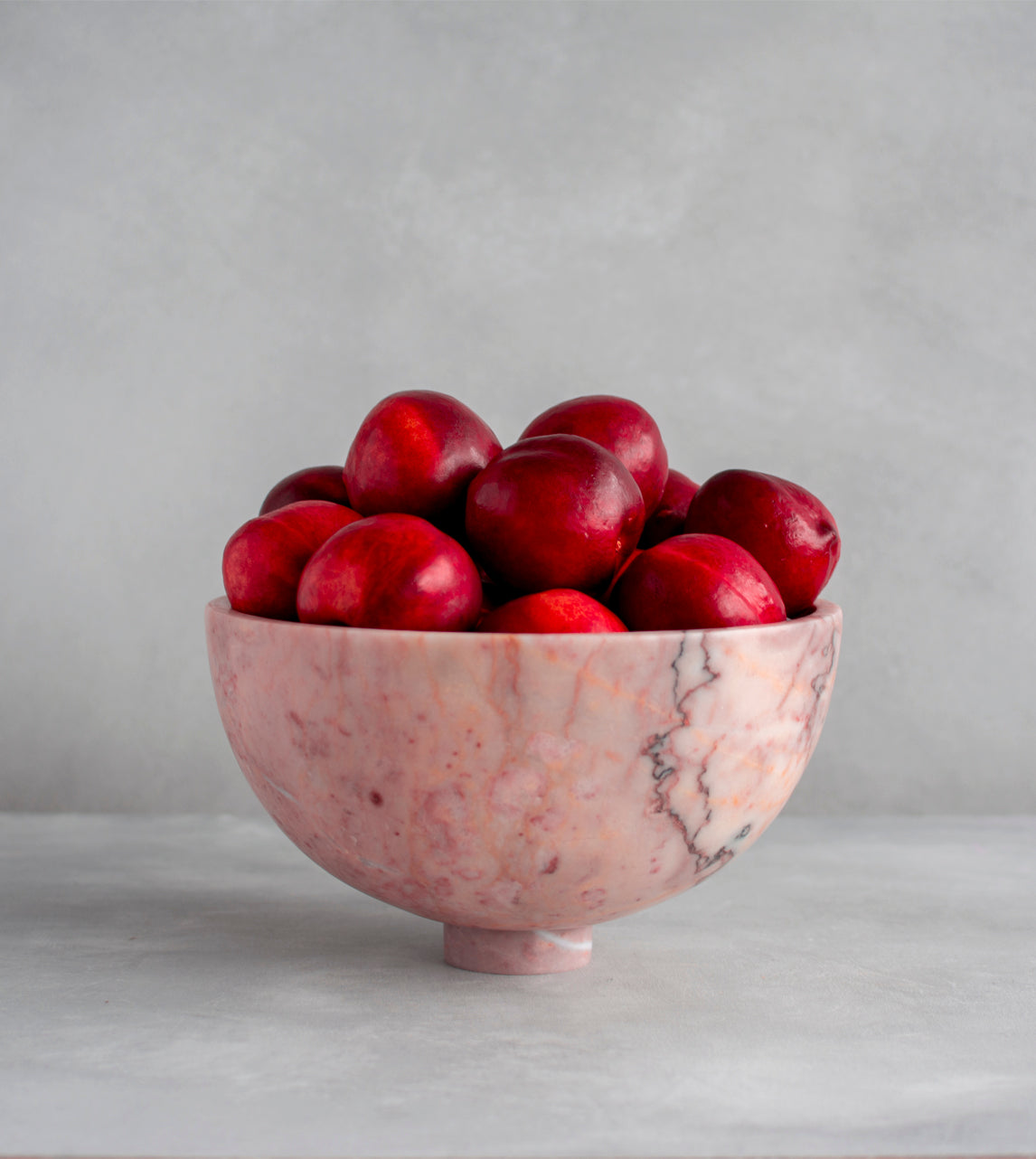 Pink marble fruit bowl with pedestal and natural veining